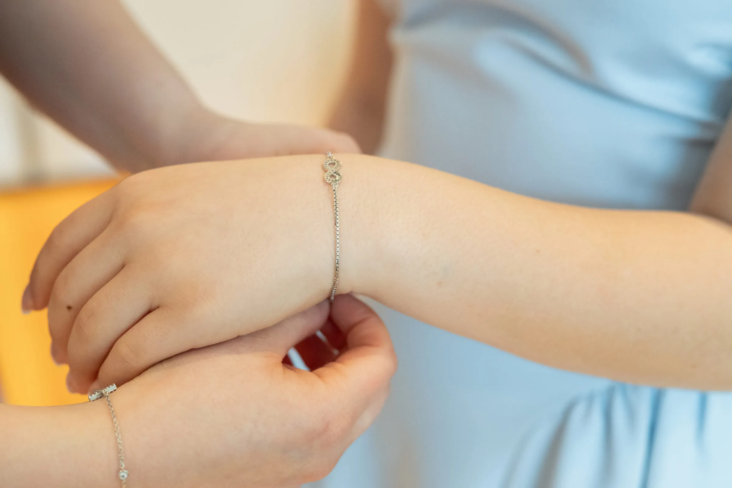 A bracelet being fastened around the girl’s wrist