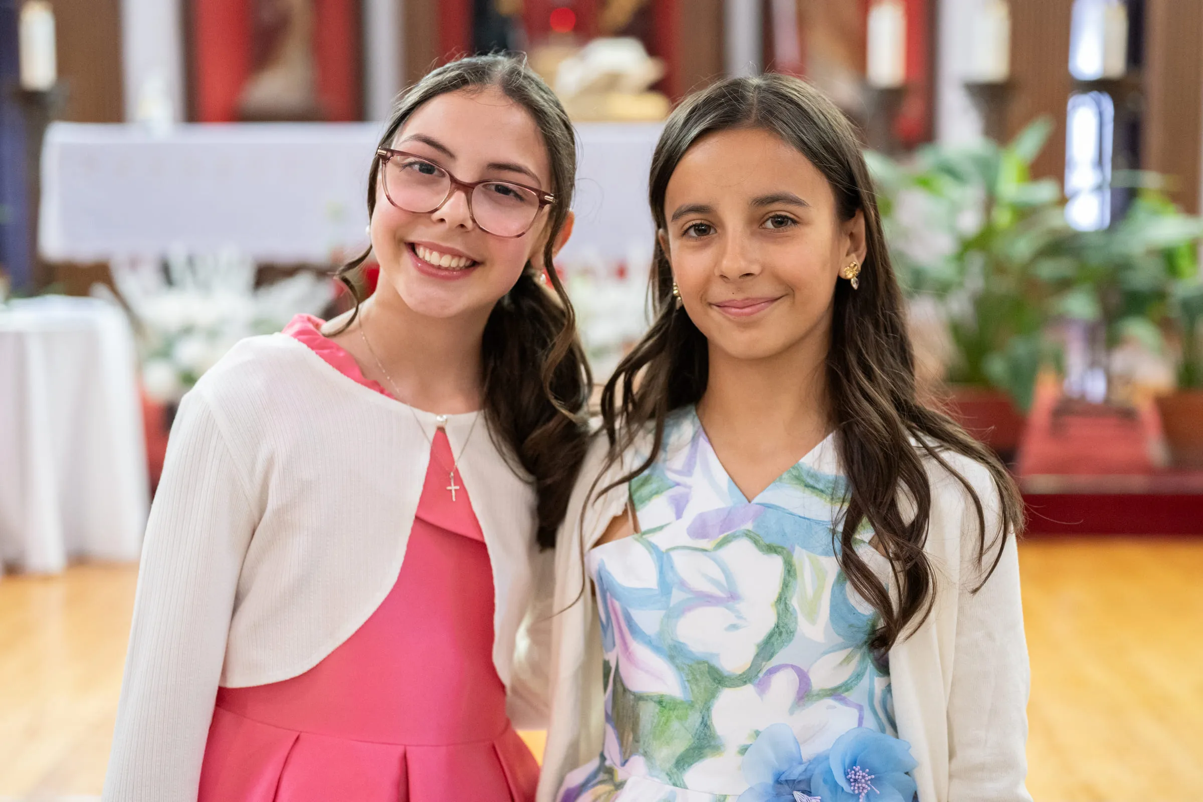 Two girls smiling together at the front of the church