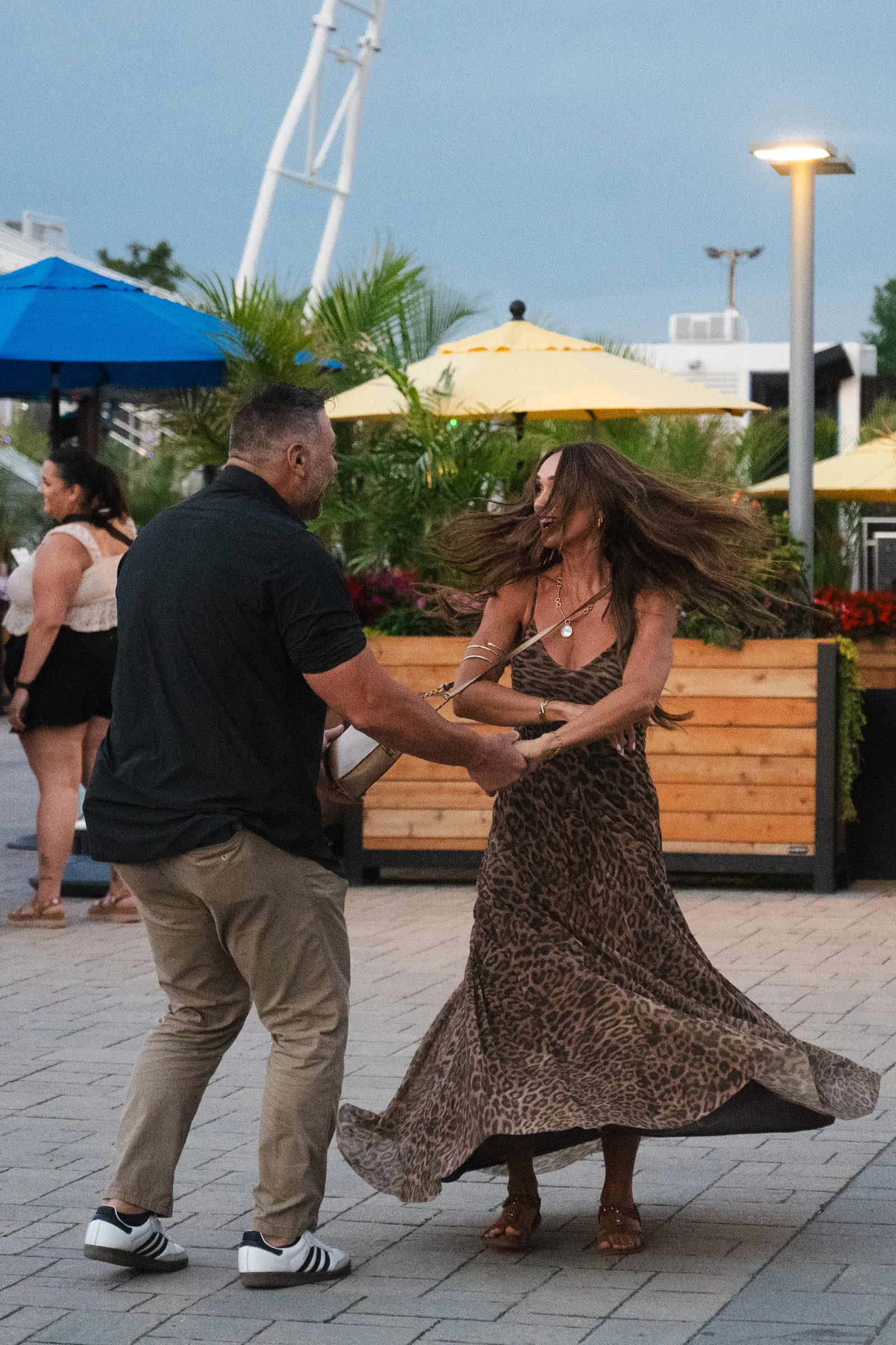 He turns her under his arm, her dress and hair swinging wide