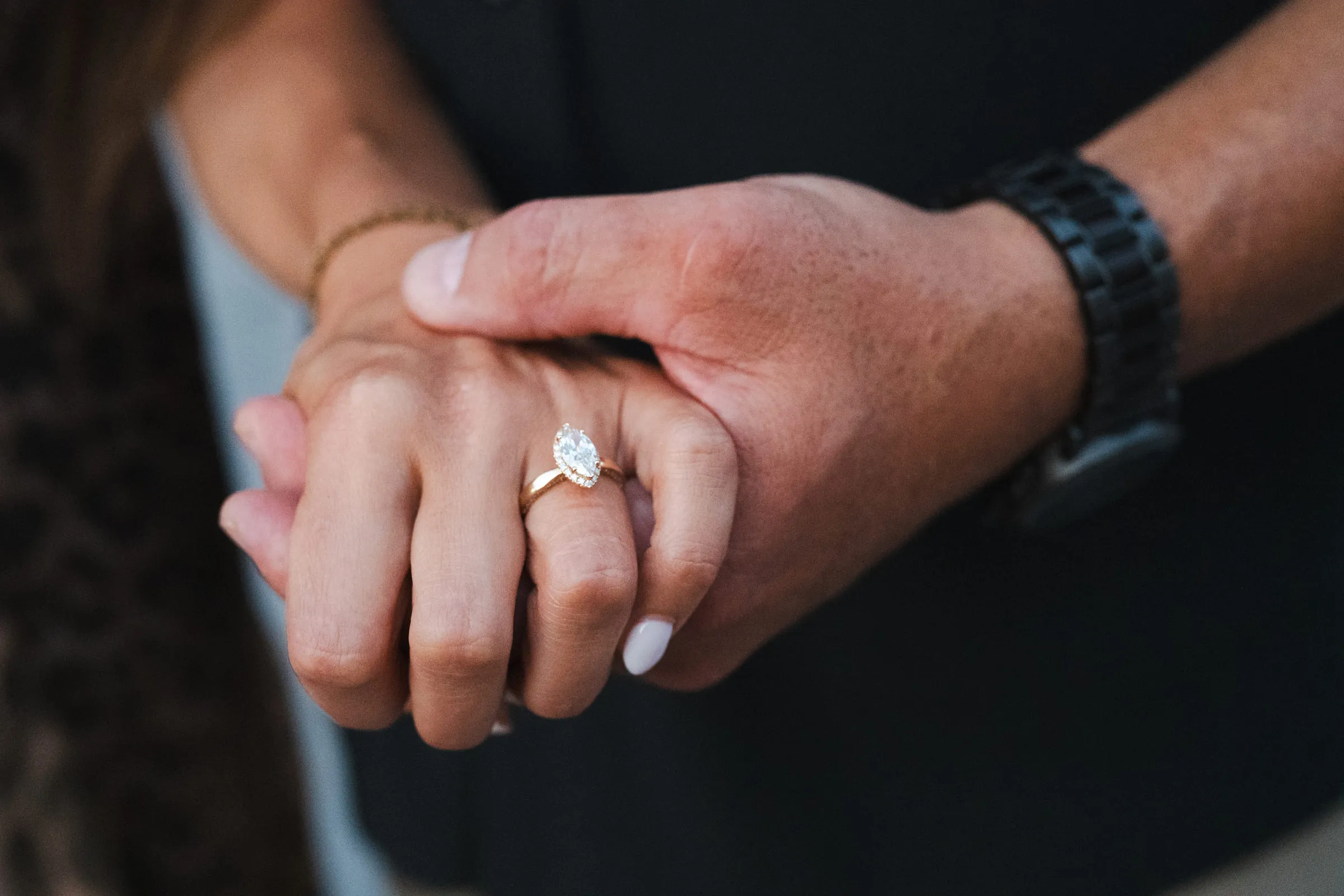Her newly engaged hand resting in his, the ring catching the light