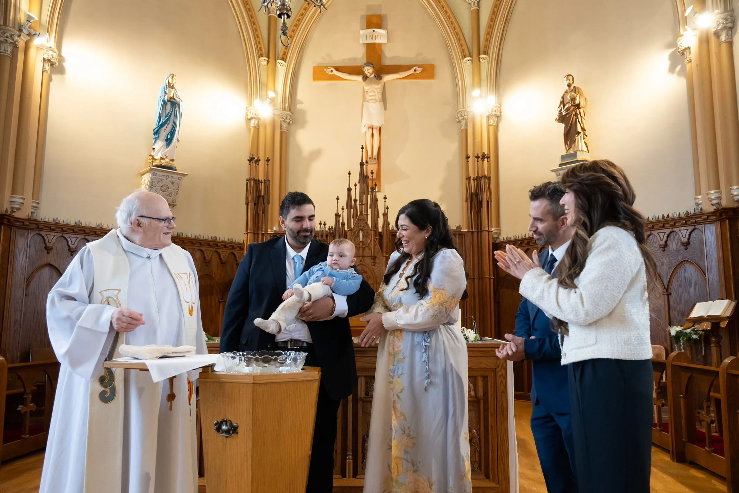 The family gathered with the priest at the altar of the church