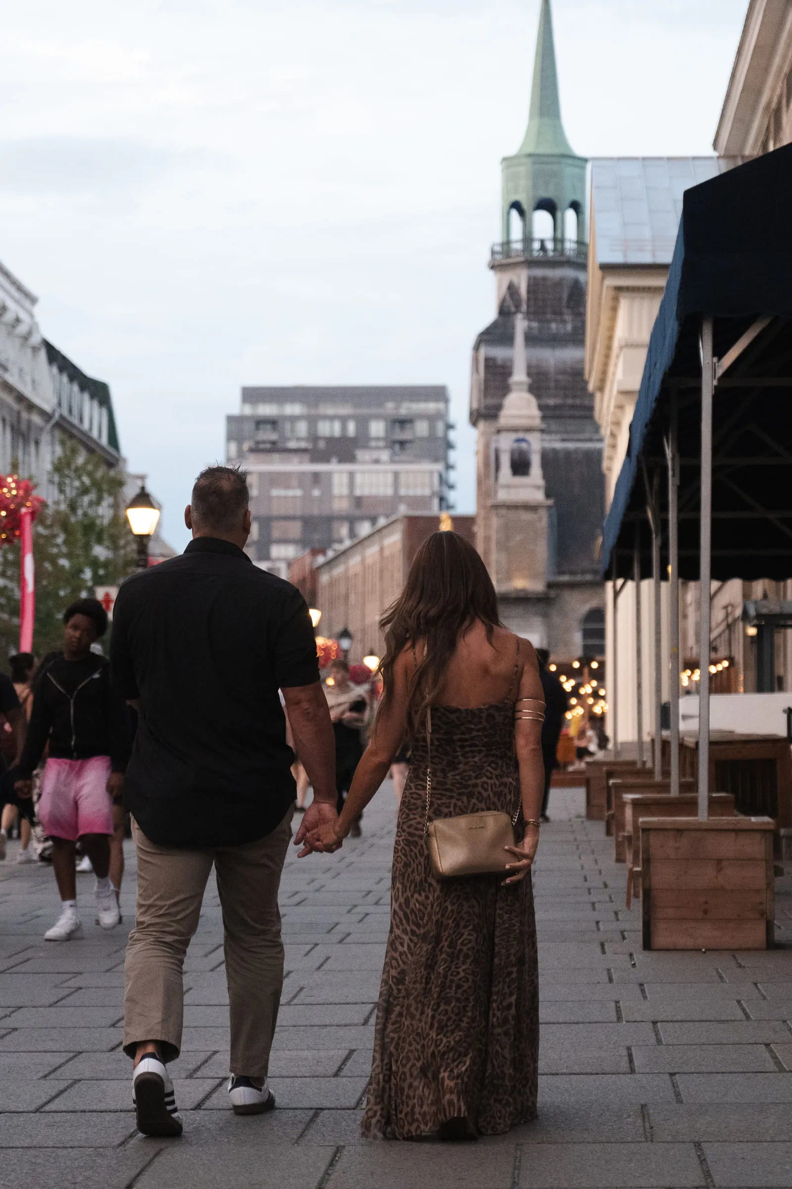 The two of them walking away hand in hand down an old-town street