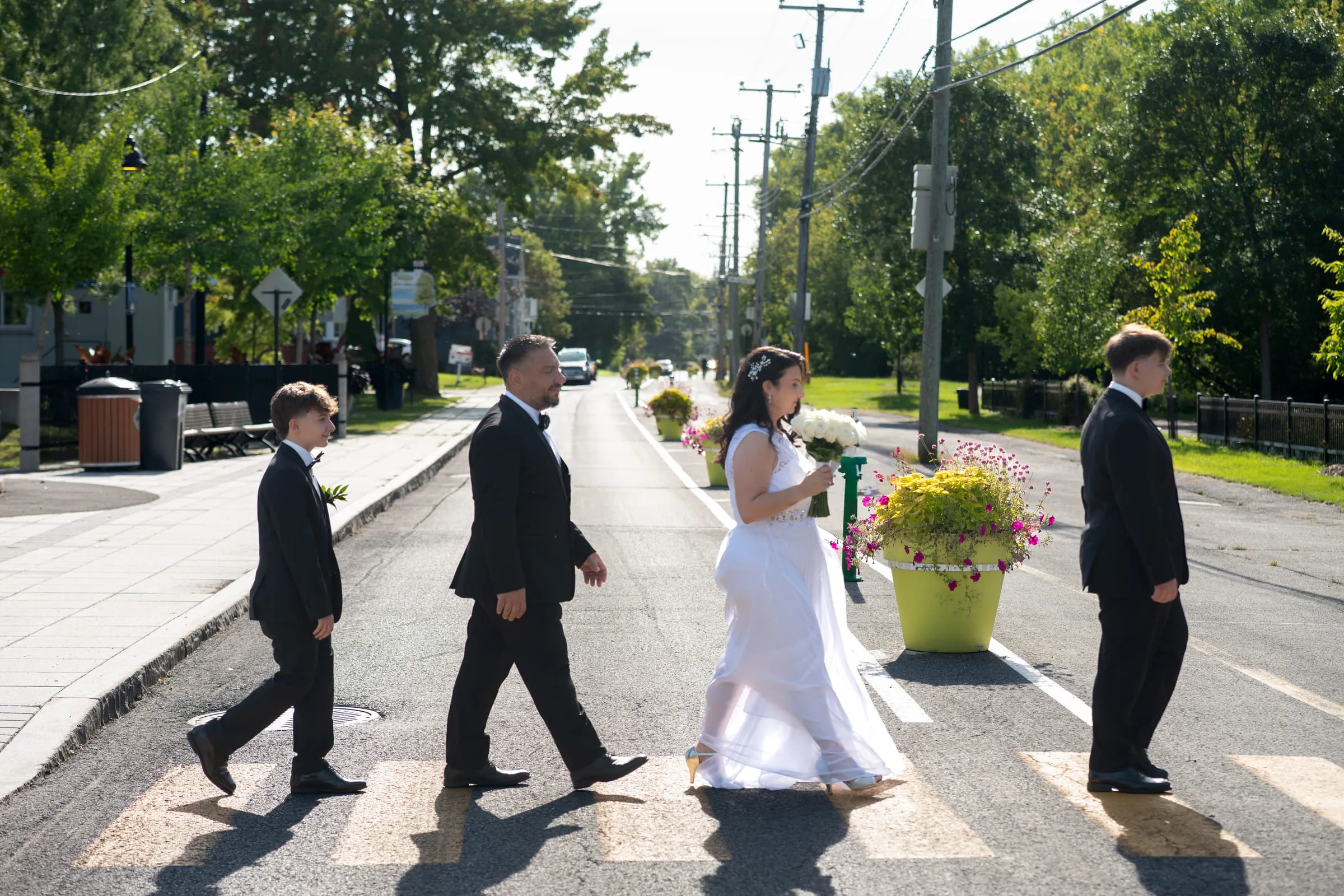 The couple and their two sons crossing a sunlit street together